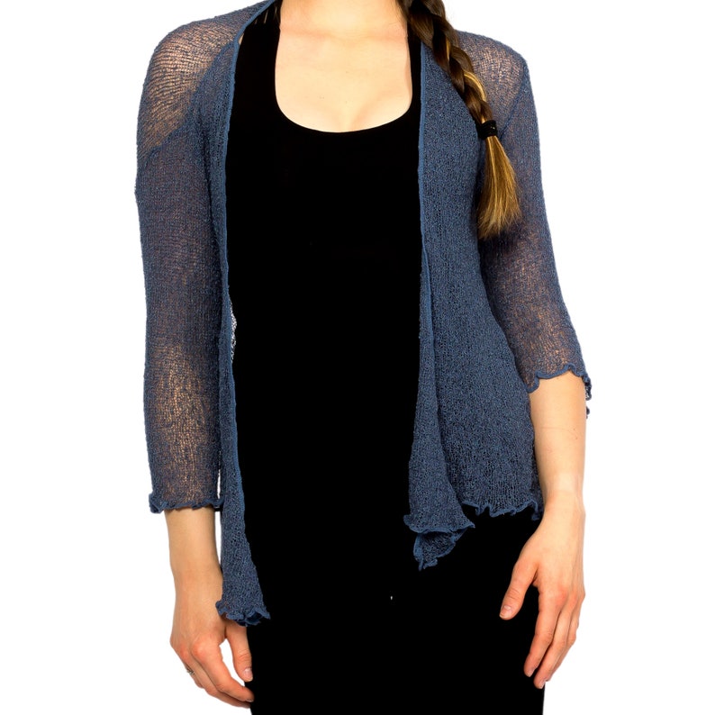 Op de afbeelding: Een blauwe gebreide cardigan met een losse pasvorm en een licht gegolfde zoom.
