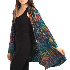 Model wearing Teal Tie Dye Long Cardigan with stripes and starburst patterns in yellow, gold, orange and fuchsia