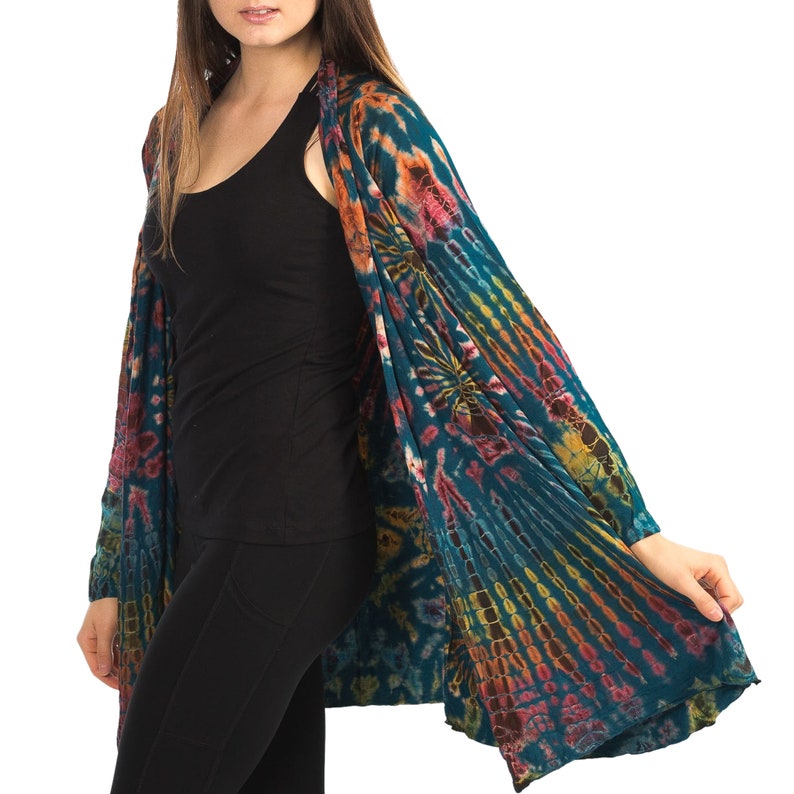 Model wearing Teal Tie Dye Long Cardigan with stripes and starburst patterns in yellow, gold, orange and fuchsia