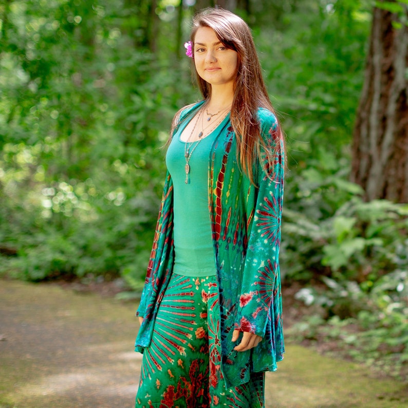 Model wearing Ocean Green Tie Dye Long Cardigan with stripes and starburst patterns in yellow, gold, orange and fuchsia