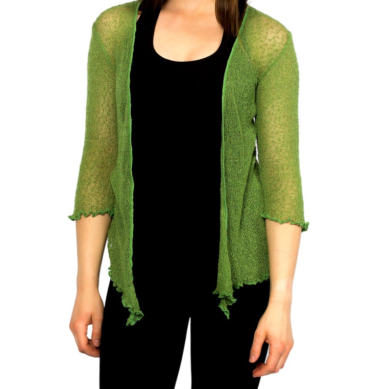Op de afbeelding: Een groene, open, lichtgewicht gebreide cardigan met 3/4 mouwen. De cardigan is gemaakt van een dunne, delicate stof en heeft een licht gekrulde zoom.