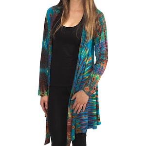 Model wearing Turquoise Tie Dye Long Cardigan with stripes and starburst patterns in yellow, gold, orange and fuchsia