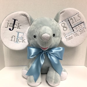 May include: A light blue plush elephant with a blue bow. The elephant's ears are white and embroidered with "Jack F.  8 pounds 21.5 inches 9:55 am June 10, 2017".