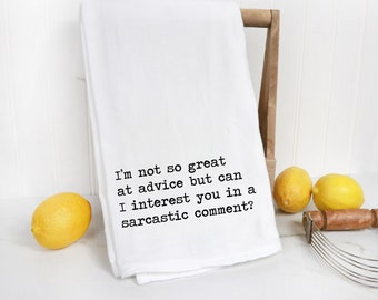 May include: White kitchen towel with the text "I'm not so great at advice but can I interest you in a sarcastic comment?" printed in black. Two yellow lemons and a wooden pastry cutter are on a white surface.