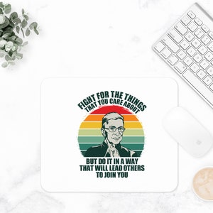 May include: A white mouse pad with a retro-style graphic of a person with glasses and the text "Fight for the things that you care about. But do it in a way that will lead others to join you."