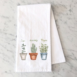 May include: White kitchen towel with a watercolor illustration of three potted herbs: sage, rosemary, and thyme.