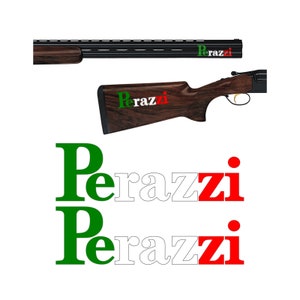 Può includere: Un fucile da caccia Perazzi con calcio in legno e canna nera. Il fucile ha un logo verde, bianco e rosso sul lato. Il logo dice "Perazzi" in lettere verdi, bianche e rosse.