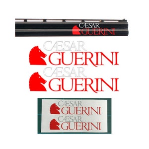 Op de afbeelding: Twee witte en rode stickers met de tekst "Caesar Guerini" en een rood paardenkoplogo. De stickers zijn op een witte achtergrond.