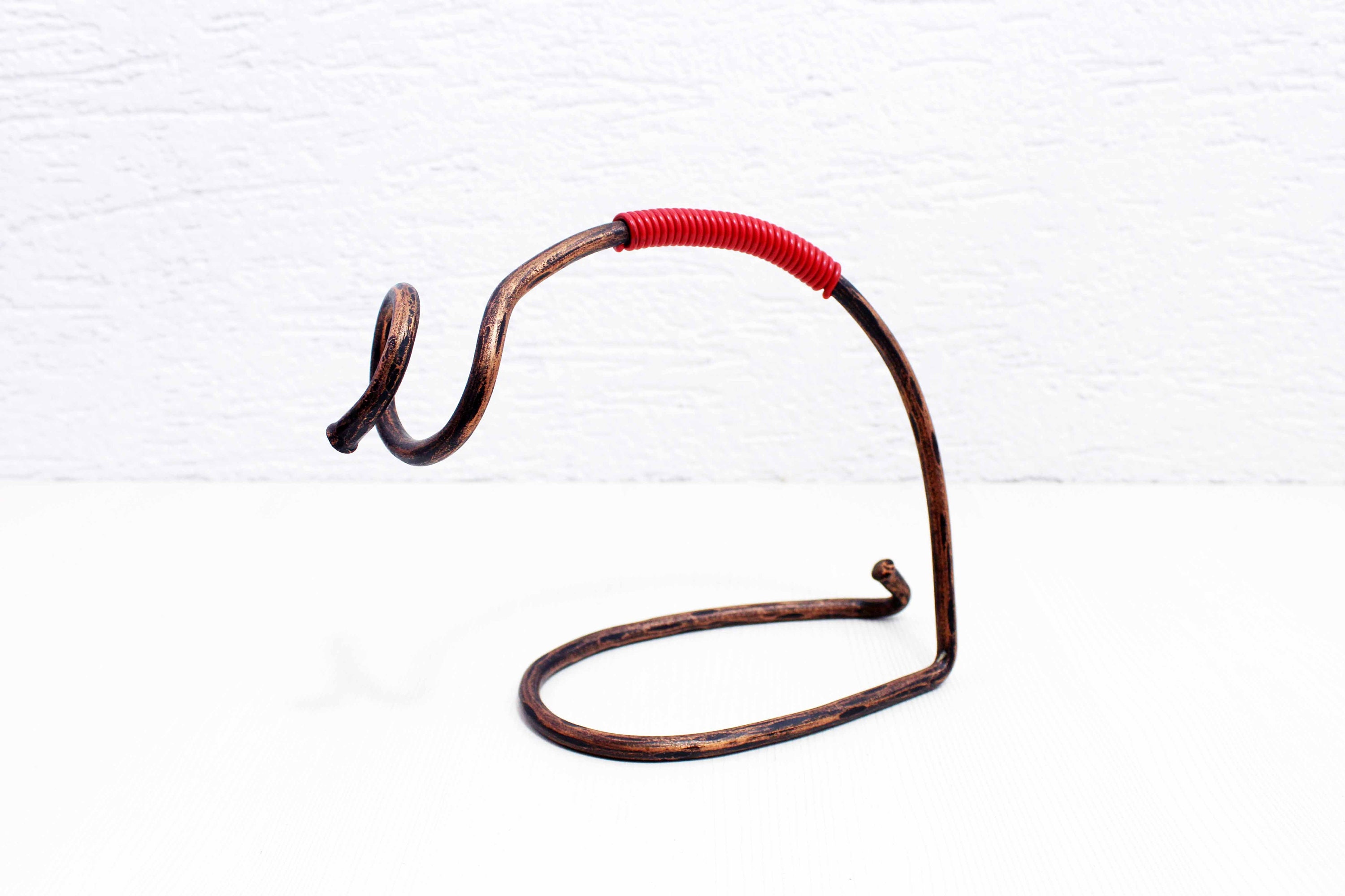 Vintage brass bottle holder in the style of Carl Aubock.