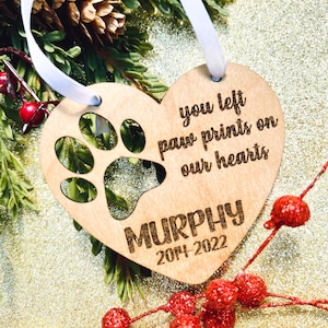 May include: Wooden heart-shaped ornament with a paw print cutout and the text "You left paw prints on our hearts" and "MURPHY 2014-2022".