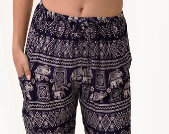 May include: A pair of navy blue pants with a white elephant print. The pants have a drawstring waist and a loose fit.
