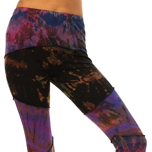 May include: Tie-dye patchwork pants in a variety of colors, including black, purple, teal, and orange. The pants have a wide waistband and a flared leg design. The fabric appears to be soft and comfortable, suitable for casual wear.