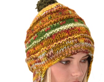 May include: A colorful knitted hat with long ear flaps and pom-poms. The hat is made of a variety of colors, including yellow, orange, red, green, and blue. The hat is worn by a person with long blonde hair.