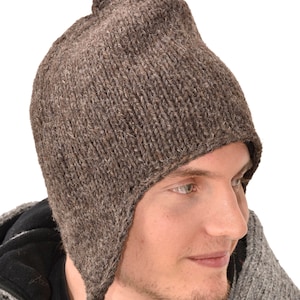 May include: A brown knitted hat with ear flaps and a long braid hanging down the back. The hat is made of wool and has a simple design.