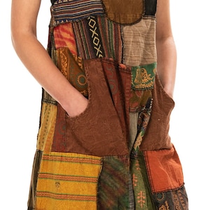 Può includere: Tuta patchwork colorata con parte superiore a bavaglino e gambe larghe. L'indumento è realizzato con vari tessuti fantasia nei toni del verde, arancione e marrone. Presenta ampie tasche e una vestibilità ampia.