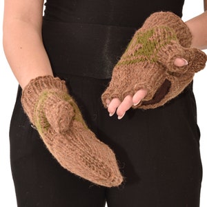 Puede incluir: Un par de guantes sin dedos marrones con rayas verdes. Los guantes están tejidos y tienen un puño marrón.
