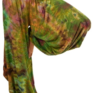 May include: Tie-dye harem pants in shades of green, yellow, and purple. The loose-fitting pants have a high waist and gathered ankles. The fabric appears soft and flowing, ideal for casual wear.