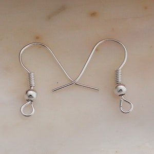 May include: A pair of silver earring hooks with a small ball at the end of each hook.