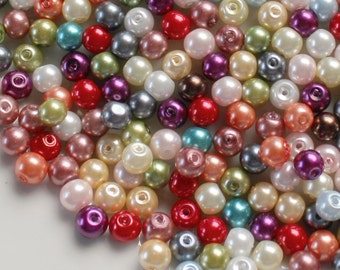 May include: A large assortment of pearl beads in various colors, including white, pink, red, blue, green, and purple. The beads are round and smooth, and they are perfect for crafting jewelry or other decorative items.