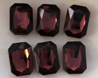 May include: Six dark purple, faceted, rectangular glass gems.