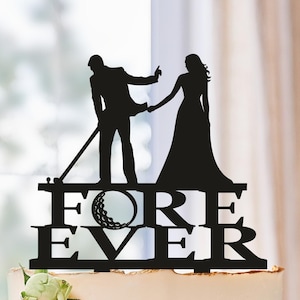 May include: Black silhouette of a couple holding hands, the groom is swinging a golf club, with a golf ball in the word "FORE" and the word "EVER" below. The topper is on a white cake with pink and white flowers.