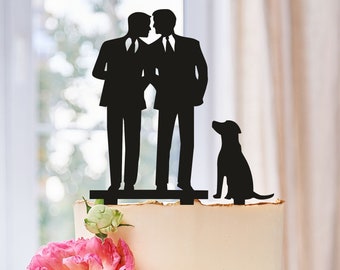 Könnte beinhalten: Ein Hochzeitstortenaufsatz mit zwei Bräutigamen in Silhouette, die sich küssen, mit einem Hund, der vor ihnen sitzt. Der Aufsatz ist aus schwarzem Acryl und befindet sich auf einer weißen Torte.