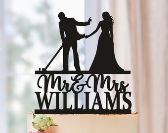 Op de afbeelding: Zwarte silhouet-taarttopper van een bruid en bruidegom met de tekst "Mr. & Mrs. Williams" op een witte taart.