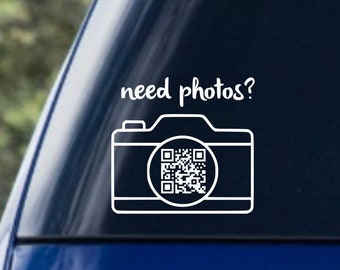 May include: White vinyl sticker with the text "need photos?" and a black and white camera icon with a QR code inside.