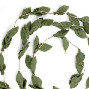 May include: A decorative garland featuring olive green felt leaves strung on a natural twine. The leaves are various sizes and shapes, creating a natural, organic aesthetic. Perfect for home decor or craft projects.
