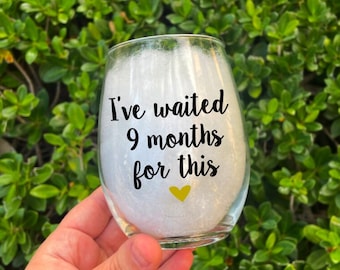 May include: A clear glass wine glass with the text "I've waited 9 months for this" and a small gold heart.