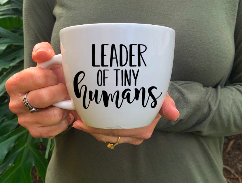 Puede incluir: Taza de cer&aacute;mica blanca con texto negro que dice "Leader of Tiny Humans".