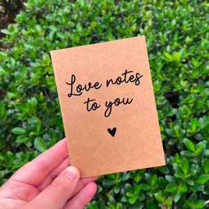May include: A brown paper notebook with the text "Love notes to you" and a small heart symbol.