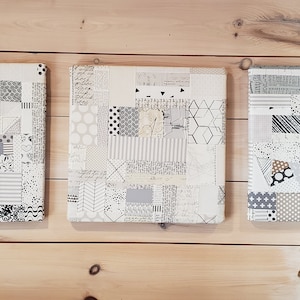 May include: Three square canvas wall art pieces with a patchwork design in black, white, and gray tones.