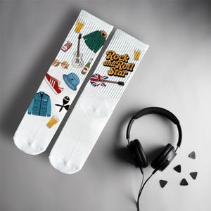 May include: White socks with rock and roll themed illustrations, including a guitar, jacket, beer, and the text "Rock and Roll Star." Black headphones and guitar plectrums are also visible in the image.