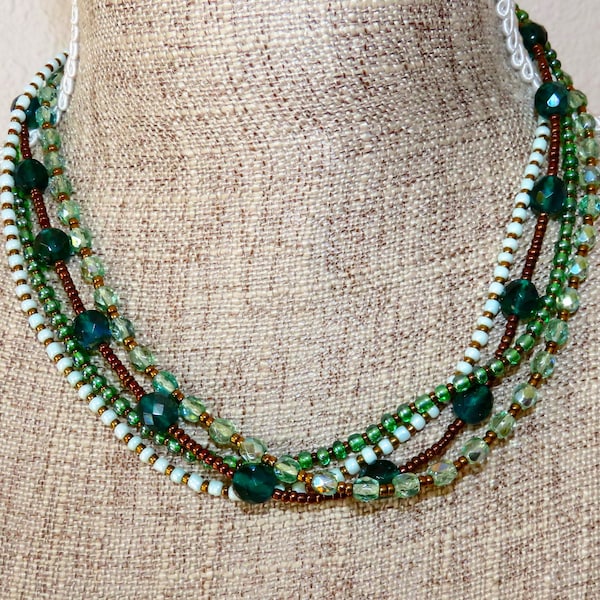 Collier lin et 4 rangées de rocailles, perles de métal et verre dans des tons verts et bronze.