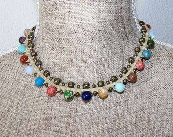 Collier court en pierres multicolores et petites perles bronze tissées dans un macramé de lin