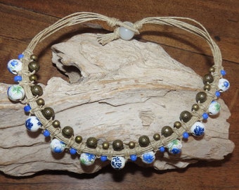 Short porcelain beaded necklace patterned floral blue and bronze and copper metal on linen macramé.