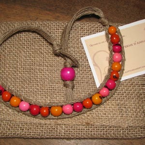 Collier court en graines d'açaï dans les tons rouge, orange et rose tissées dans la ficelle de lin lin image 1