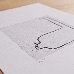 May include: A black and white line drawing of a curved shape resembling a bottle or a vase. The drawing is on a white background with the text "PK22" in the bottom right corner.