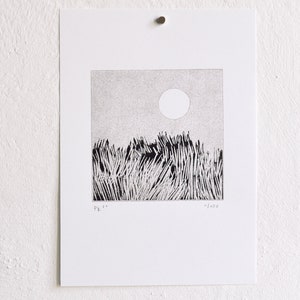 May include: A black and white square art print on white paper featuring a stippled sky with a circular sun above a field of tall, dense grass. The print includes the handwritten text "PK 21" on the bottom left and "11/100" on the bottom right.