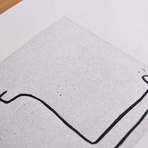 May include: A black and white line drawing of a person sitting with their legs stretched out in front of them.