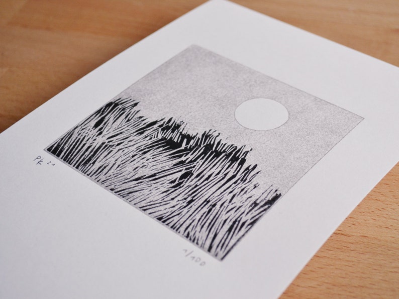 May include: A square black and white linocut print on white paper featuring a field of tall grass under a circular sun. The print includes the handwritten text 'Pf 21' on the left and '1/100' on the bottom, indicating a limited edition artwork.