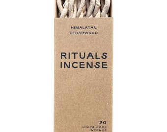 May include: A brown cardboard box with a white label that reads "Himalayan Cedarwood Rituals Incense 20 Lokta Rope Incense". The box contains a bundle of white incense sticks.