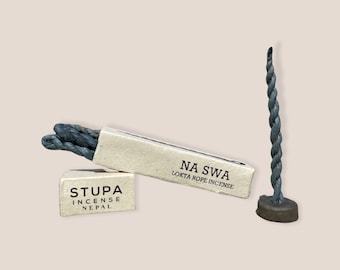 Könnte beinhalten: Verschiedene Räucherstäbchen-Produkte. Zwei kleine, rechteckige Schachteln mit der Aufschrift "STUPA INCENSE NEPAL" und "NA SWA LOKTA ROPE INCENSE". Ein Bündel grauer Seil-Räucherstäbchen und ein grauer Räucherstäbchenhalter.