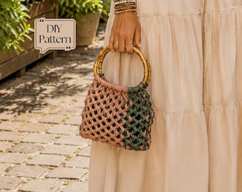 May include: A macrame handbag featuring a knotted design in dusty pink and dark green, equipped with two circular bamboo handles. The bag displays a text box in the upper left corner with the words DIY Pattern. The construction is a woven cord.