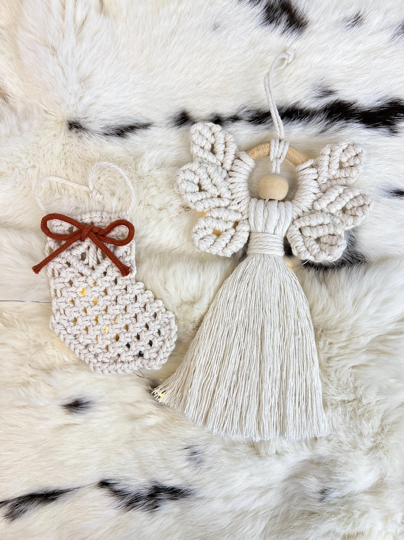 Macramé Christmas ornaments — a tasselled angel and a small crochet-style stocking with a suede bow — displayed on soft fur