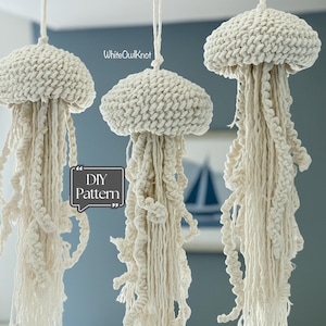 May include: Three off-white crocheted jellyfish hanging decorations with textured bell-shaped tops and long, dangling cord tentacles. The text WhiteOwlKnot and DIY Pattern are visible in the image. These hanging ornaments feature a knotted fiber construction.