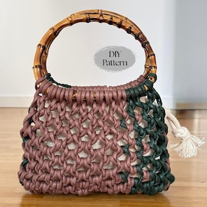 May include: A handmade macrame bag with a bamboo handle. The bag features a woven design in shades of mauve and green, with a cream-colored lining. The handle is made of polished bamboo. The text "DIY Pattern" is visible.