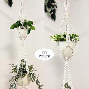 May include: A double-tiered macrame plant hanger in white, holding two white ceramic pots filled with green plants. The macrame design features intricate knots and a braided pattern. The text "DIY Pattern" is visible.
