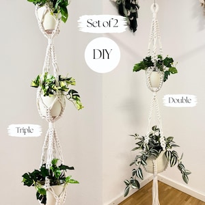 Op de afbeelding: Twee macramé plantenhangers, één drievoudige en één dubbele, elk met een witte keramische pot met groene planten. De hangers zijn gemaakt van wit touw en hangen tegen een witte muur. De tekst "Set of 2" en "DIY" is ook zichtbaar.